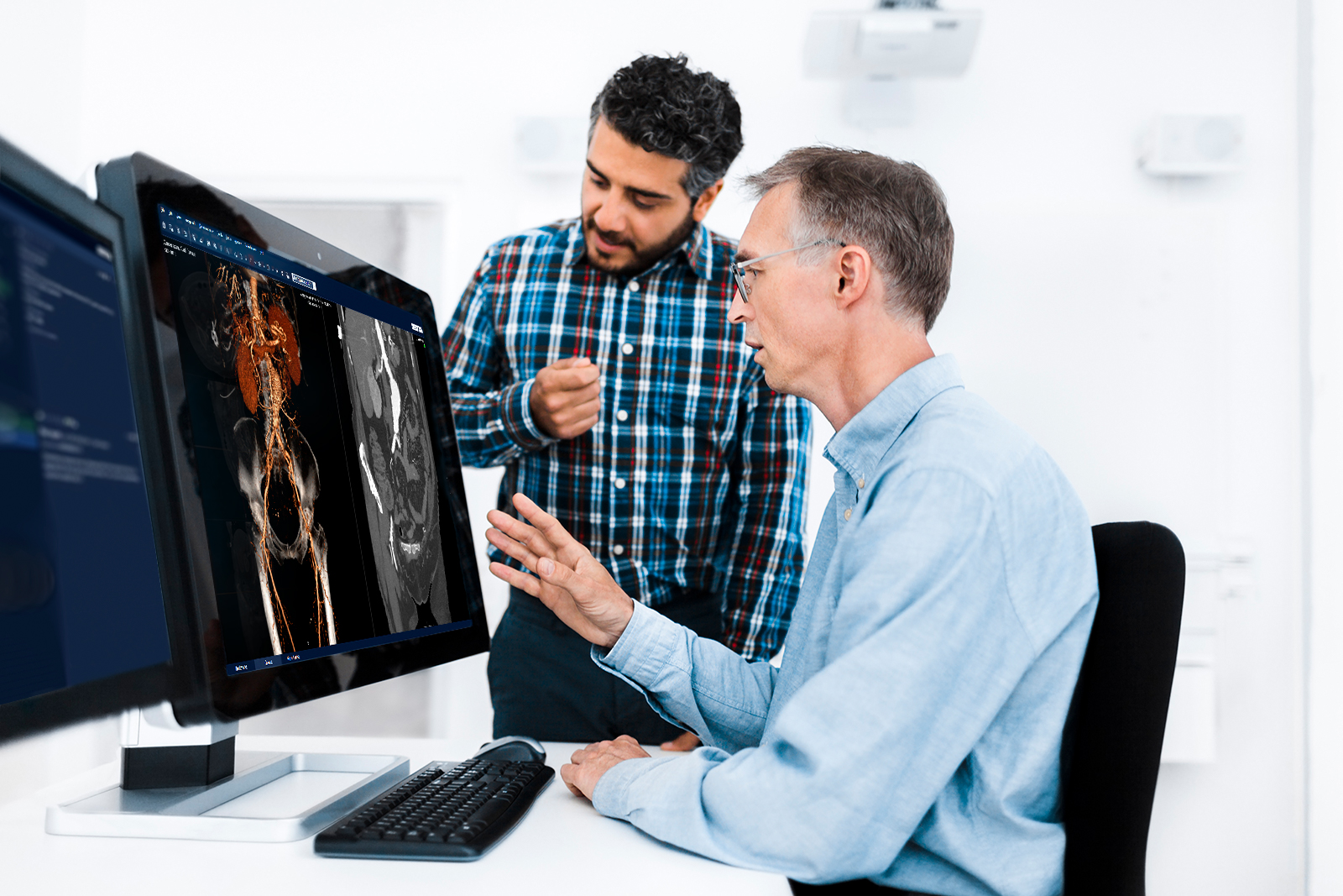 Two male radiologists looking at a patient's vessels using the Sectra Vessel Analysis application.