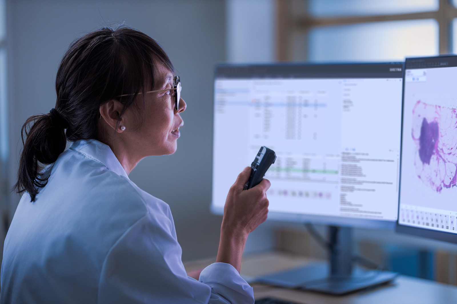 Female pathologist in front of a monitor with speech recognition