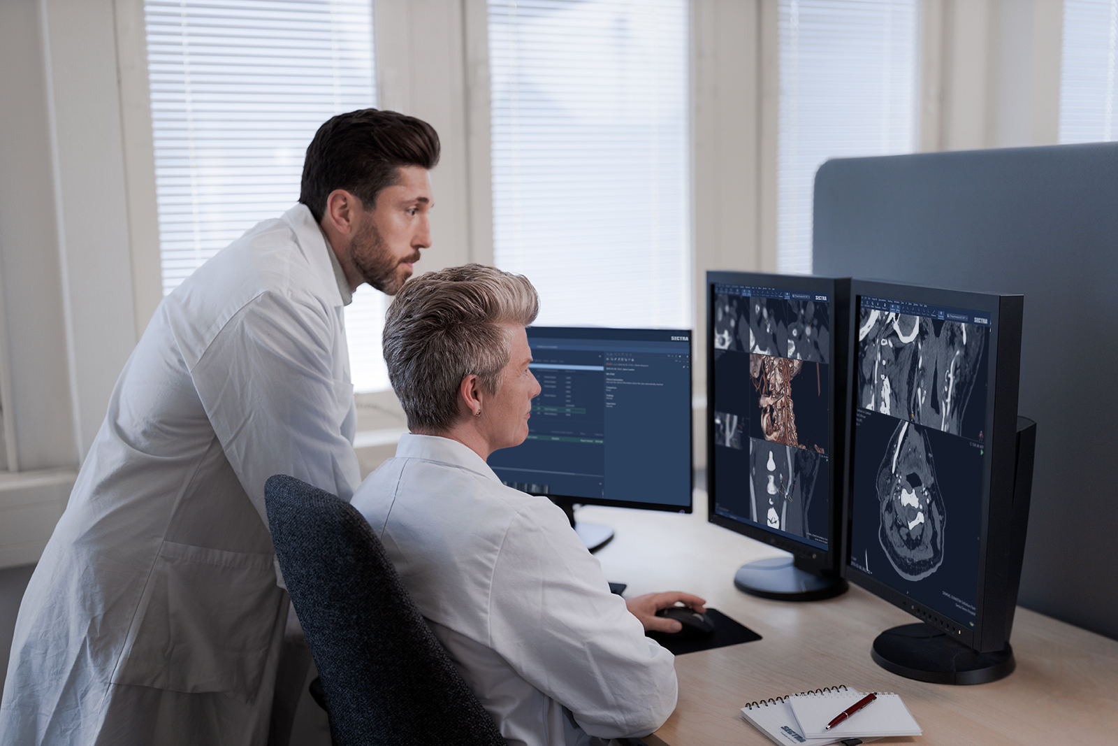 two physicians working at a radiology workstation
